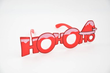 Beyaz arka planda izole edilmiş Noel gözlükleri. Kar sembollü kırmızı Noel gözlüğü süslemesi. Ho ho ho yazıtı