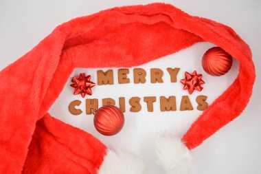 Zencefilli çörekler Mutlu Noeller ve kırmızı Noel Baba şapkası Kırmızı Noel süslemeleri ile beyaz arka planda izole