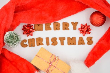 Zencefilli çörekler Mutlu Noeller ve kırmızı Noel Baba şapkası Kırmızı Noel süslemeleri ile beyaz arka planda izole