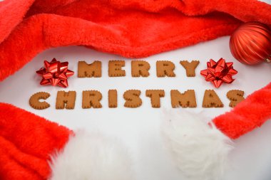 Zencefilli çörekler Mutlu Noeller ve kırmızı Noel Baba şapkası Kırmızı Noel süslemeleri ile beyaz arka planda izole