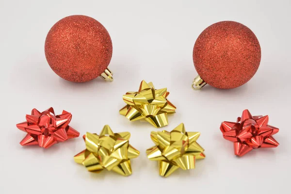 Christmas decorations with two red glitter balls and red and gold colored stars on a white background.
