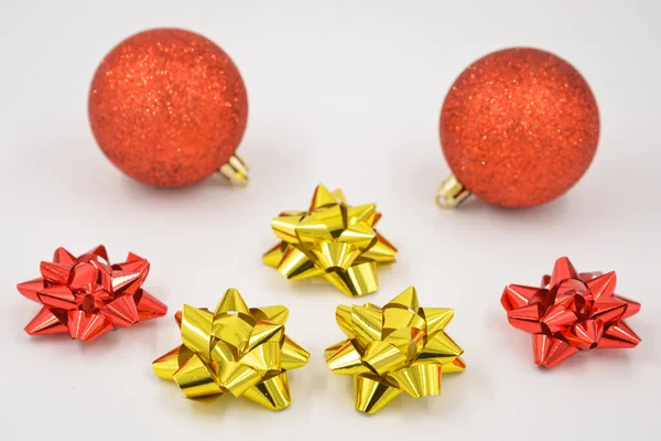 Christmas decorations with two red glitter balls and red and gold colored stars on a white background.