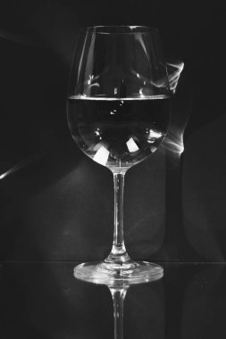 Siyah arka planda yansıması olan su dolu kristal bir bardakla hayat.