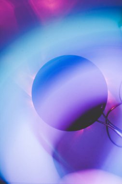 black frying pan in the dark on a white background with blurred lights in a long exposure