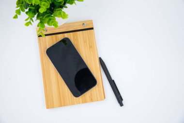 Back to school concept. Top view photo of school supplies smartphone on notepad pens binder clips and adhesive tape on isolated pastel white background with copyspace