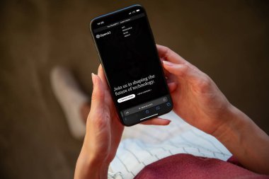 Riga, Letonya - 02 Şubat 2023: Kadınların elinde mobil ekranda OpenAI web sayfası.