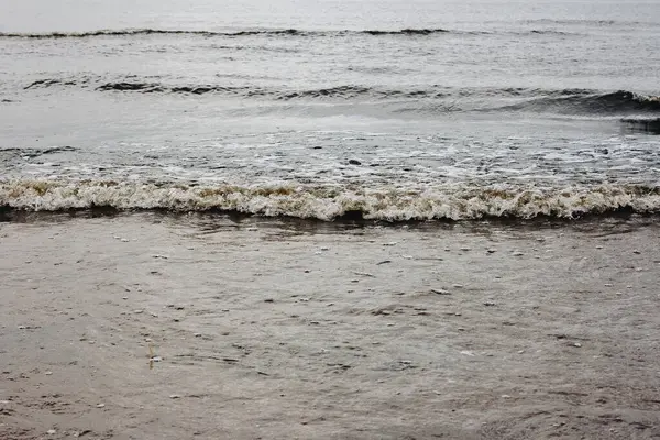 太阳升起时平静的海浪冲向海滩的特写 — 图库照片