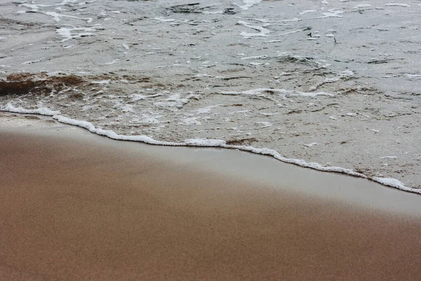 太阳升起时平静的海浪冲向海滩的特写 — 图库照片