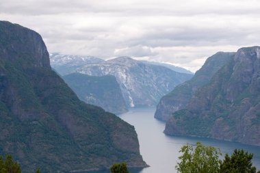 Stegastein 'in bakış açısından bulutlu bir yaz gününde Norveç dağlarının doğa manzarası. Dağlarda mavi UV radyasyonu.