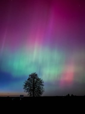 Güzel yeşil ve kırmızı bir aurora tepelerde dans ediyor.