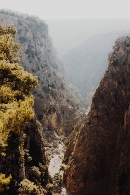 Dar, derin bir dağ geçidinin tepesinden manzarayı seyrek taş duvarlar ve ender çalılar, Girit, Yunanistan