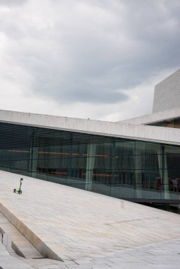 Oslo, Norveç - 12 Temmuz 2023 - Oslo Opera Binası Meydanı, eğimli çatıda tek başına duran scooter.