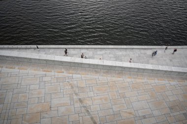Oslo, Norveç - 12 Temmuz 2023 - Oslo Operası 'nın etrafında gün batımında yürüyen insanlar