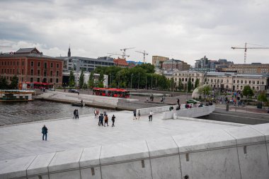 Oslo, Norway - July 12, 2023 - People walking around the Oslo Opera House at sunset clipart