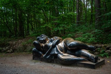 OSLO, NORway - 12 Temmuz 2023: Ekebergparken heykel parkında alüminyum heykel. Yan yatmış bir kadın.