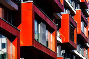 Modern Apartment Facade with Bold Red Panels, Glass Windows, and Playful Light and Shadow clipart