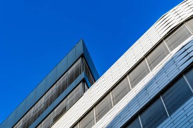 Çağdaş Mimari Tasarım Kıvrımlı ve Açı Yüzlü Parlak Mavi Gökyüzüne Karşı