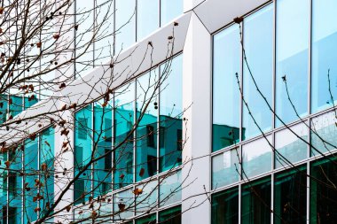 Modern Glass Facade with Reflective Panels and Angular Architectural Details in Urban Design clipart