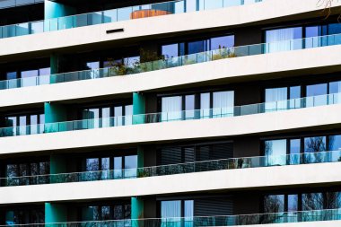 Modern Residential Building with Spacious Balconies and Glass Railings in Urban Setting clipart