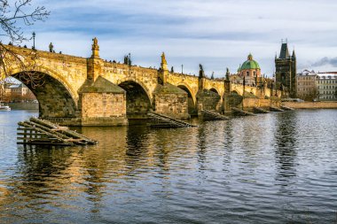 Prag, Çek Cumhuriyeti - 4 Ocak 2025: Prag 'daki Charles Köprüsü' nün Vltava Nehri Yansımaları Altından Saati