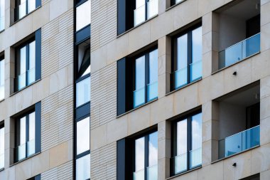 Bej kaplamalı ve dikey cam bölümlü şık kentsel apartman