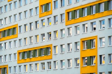 Dönüşümlü sarı ve yeşil pencere aksanıyla yerleşim alanı ön cephesi