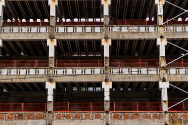 Beton yapı ve kırmızı güvenlik bariyerleriyle inşaat halinde.