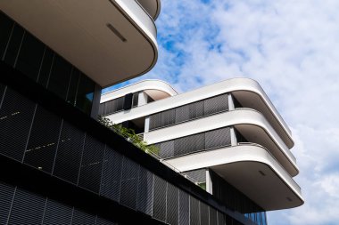 Kavisli beyaz balkonları ve ritmik güneş gözlükleriyle çağdaş konut cephesi