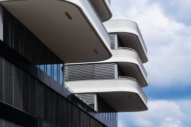 Kavisli beyaz balkonları ve ritmik güneş gözlükleriyle çağdaş konut cephesi