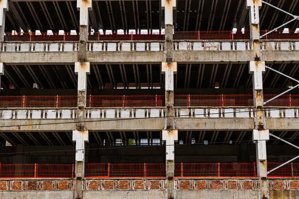 Beton yapı ve kırmızı güvenlik bariyerleriyle inşaat halinde.