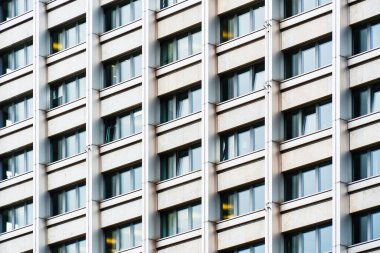 Modern ofis binası cephesi geometrik beyaz dikey paneller ve ritmik desende renk tonlarıyla