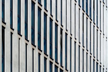 Modern ofis binası cephesi geometrik beyaz dikey paneller ve ritmik desende renk tonlarıyla