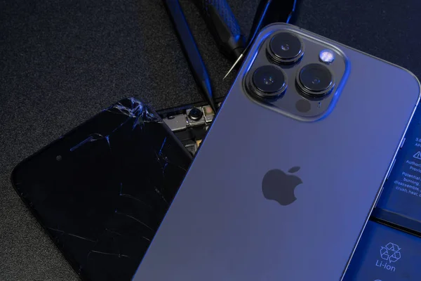 South Tyrol, Italy - Jan. 7. 2023: Apple iPhone 13 Pro on top of old iPhone and repair tools