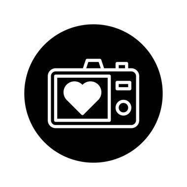 Beyaz bir kamera simgesi, ekranında siyah bir çembere karşı duran bir kalp var. Fotoğrafçılık, aşk ve anıları temsil eder..