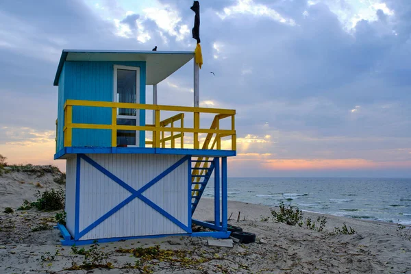 stock image Lifeguard tower sandy sea beach with a raised black flag meaning swimming is prohibited