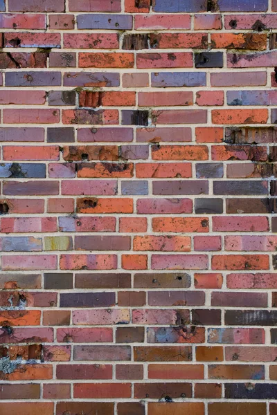 レンガの壁は 第二次世界大戦後の痕跡弾丸と破片と古いドイツの赤焼きレンガを作った — ストック写真