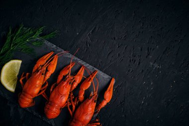 Kaynamış nehir kerevitleri, limon ve Dillon tahtası ve koyu arkaplan.