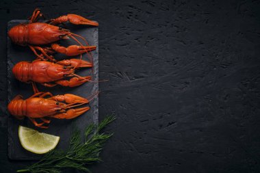 Kaynamış nehir kerevitleri, limon ve Dillon tahtası ve koyu arkaplan.