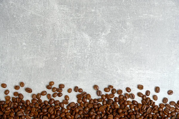 Roasted coffee beans background light concrete texture