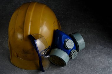 Beton zeminde solunum cihazı, gözlük ve madenci koruyucu kask.