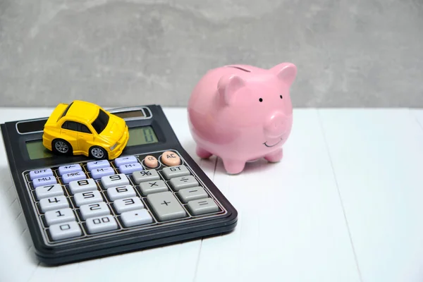 Piggy bank, calculator and car, concept spending and accumulating finances on car