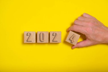 Wooden cubes with numbers 2024 yellow background are made by hand