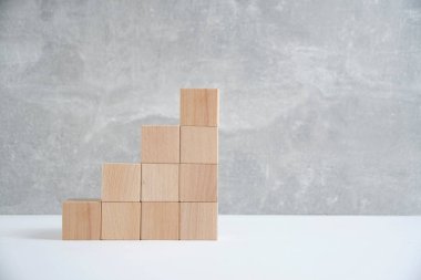 Steps made of wooden cubes light concrete background.Empty space for text