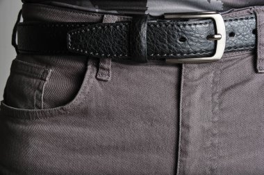 Buttoned black, male leather belt worn on jeans