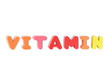 Word vitamin is laid out letters white background