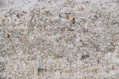 Old, gray concrete wall with peeling white paint