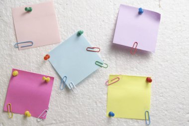 Colorful stickers for notes are attached wall with help stationery buttons