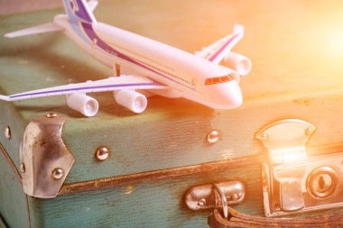 Old, vintage, retro suitcase and toy airplane in sunlight.Concept recreation and travel
