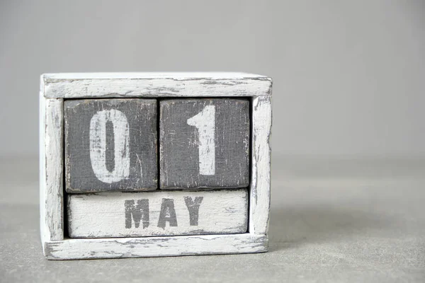 May 1, Wooden desktop calendar gray background.Spring month depicted on cubes.Place for your ideas.Labor day