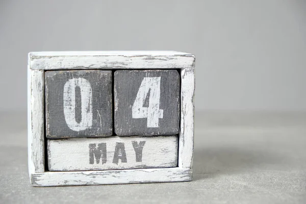 May 4, Wooden desktop calendar gray background.Spring month depicted on cubes.Place for your ideas.International Firefighters Day